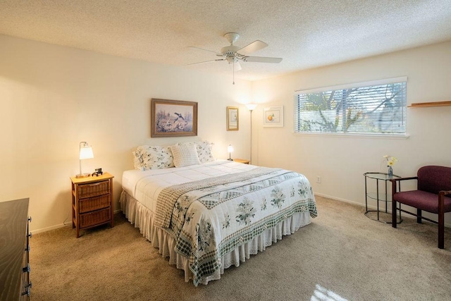 bedroom with ceiling fan, light carpet, and a textured ceiling