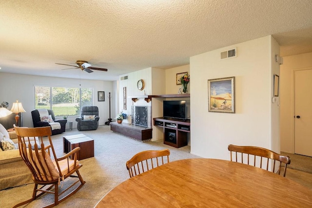 carpeted dining room featuring ceiling fan and a textured ceiling