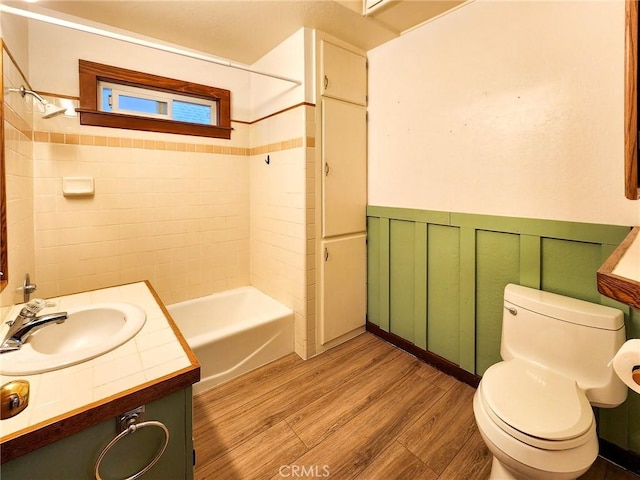 full bathroom with tiled shower / bath combo, hardwood / wood-style flooring, toilet, and vanity