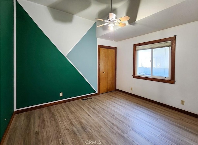 unfurnished bedroom featuring hardwood / wood-style flooring, ceiling fan, and vaulted ceiling