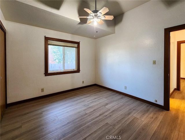 unfurnished room with hardwood / wood-style flooring, vaulted ceiling, and ceiling fan