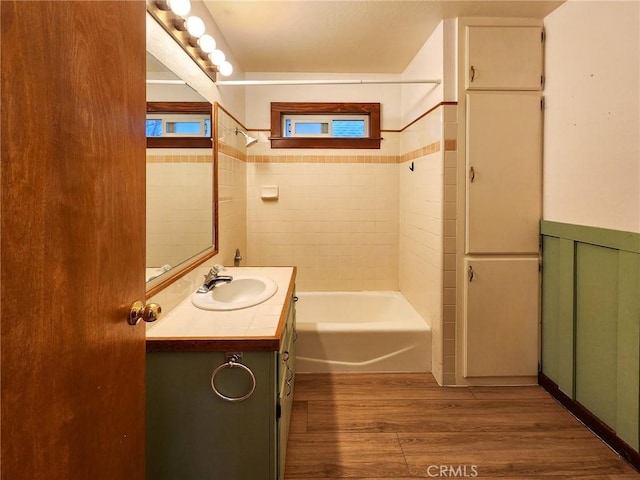 bathroom with vanity, hardwood / wood-style flooring, and tiled shower / bath combo