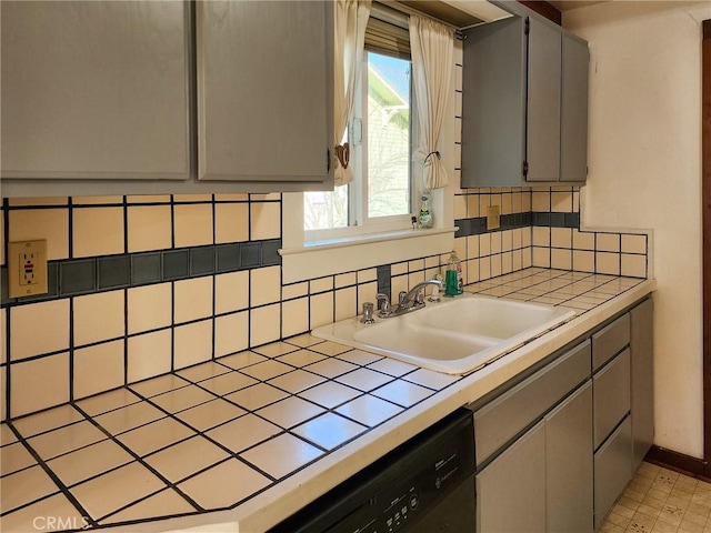 kitchen featuring sink, black dishwasher, tile counters, and gray cabinets