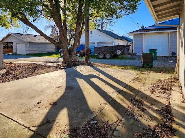 view of yard featuring a garage and an outbuilding