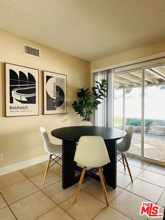 tiled dining room with a textured ceiling