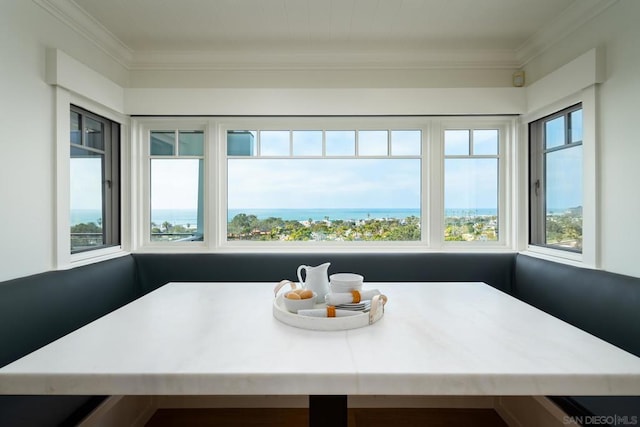 sunroom with breakfast area and a water view