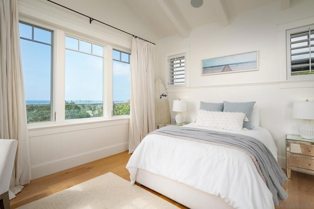 bedroom featuring lofted ceiling with beams and light wood-type flooring