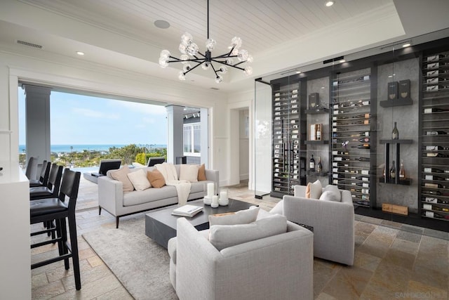 living room featuring a water view, wood ceiling, a tray ceiling, and a chandelier