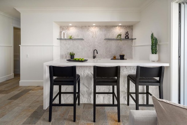 bar with crown molding and sink