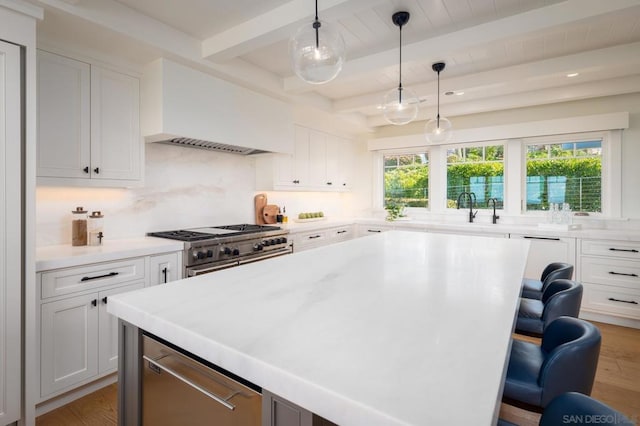 kitchen featuring white cabinets, a kitchen breakfast bar, beam ceiling, and high end stainless steel range oven