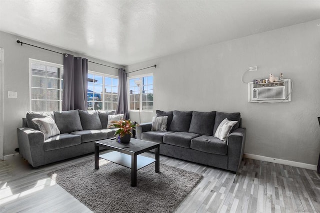 living room with hardwood / wood-style floors and a wall unit AC