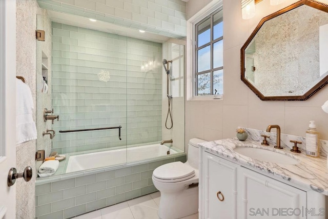 full bathroom featuring tile patterned floors, vanity, enclosed tub / shower combo, and toilet