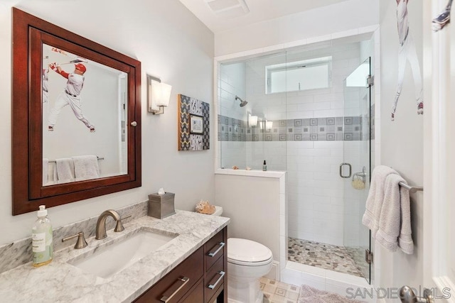 bathroom featuring vanity, toilet, and a shower with shower door