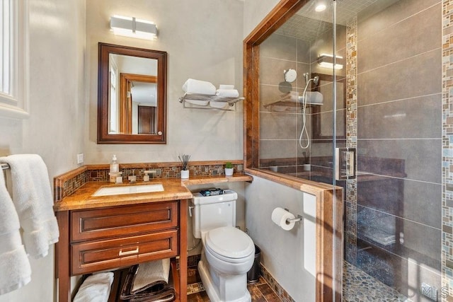 bathroom featuring vanity, toilet, and a shower with door