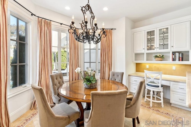 tiled dining area featuring built in desk and a chandelier