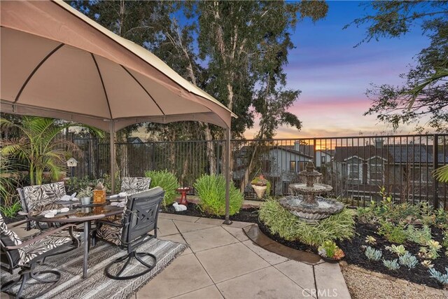 patio terrace at dusk featuring a gazebo