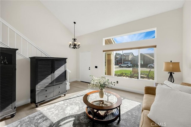 living room featuring light wood-type flooring, high vaulted ceiling, and a notable chandelier