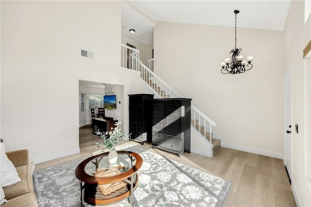 living room featuring an inviting chandelier, light hardwood / wood-style flooring, and high vaulted ceiling