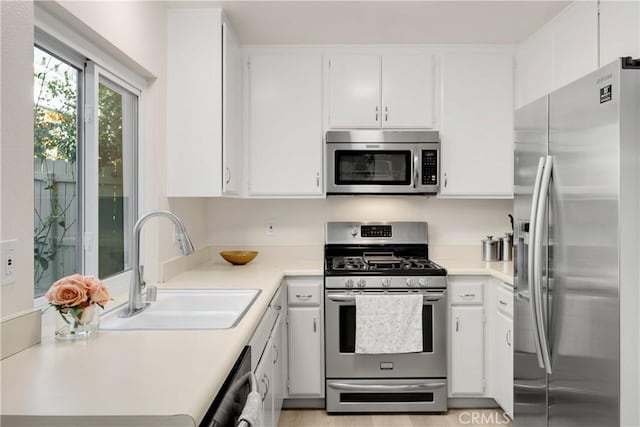 kitchen with white cabinets, stainless steel appliances, and sink