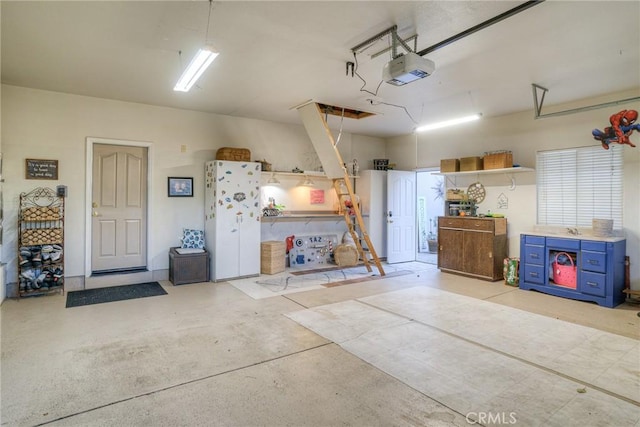 garage with a garage door opener and white refrigerator