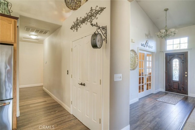 entryway with french doors, dark hardwood / wood-style floors, and an inviting chandelier