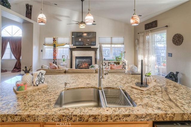 kitchen with decorative light fixtures, ceiling fan, and sink