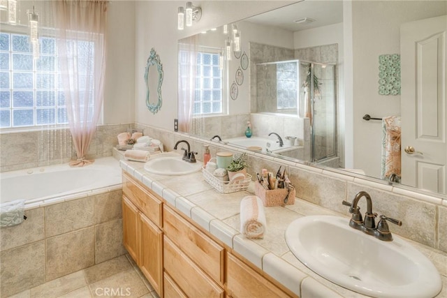 bathroom with tile patterned floors, vanity, and separate shower and tub