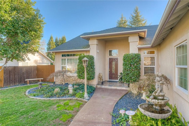 view of exterior entry with a yard