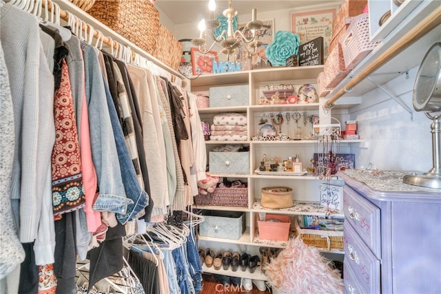 walk in closet featuring a notable chandelier