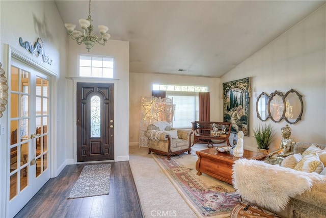 entryway with french doors, plenty of natural light, dark wood-type flooring, and a notable chandelier