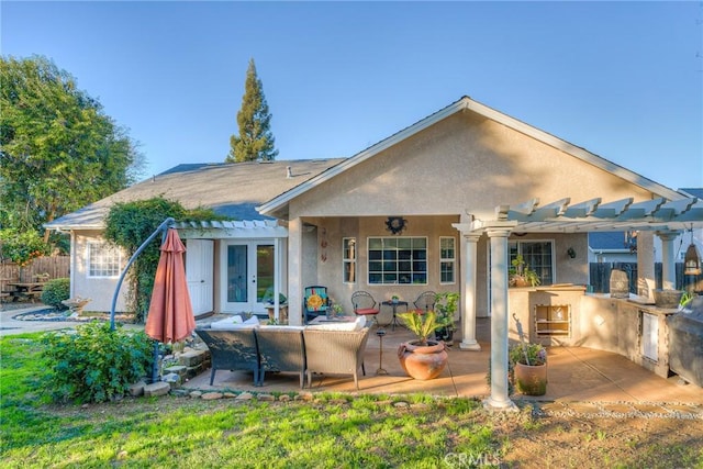 back of property featuring a pergola, french doors, a patio, and exterior kitchen