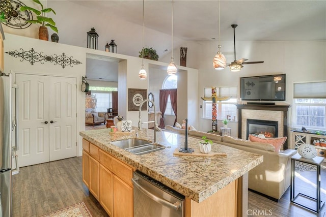 kitchen with stainless steel appliances, ceiling fan, sink, decorative light fixtures, and an island with sink