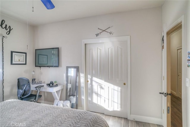 bedroom with ceiling fan, light wood-type flooring, and a closet