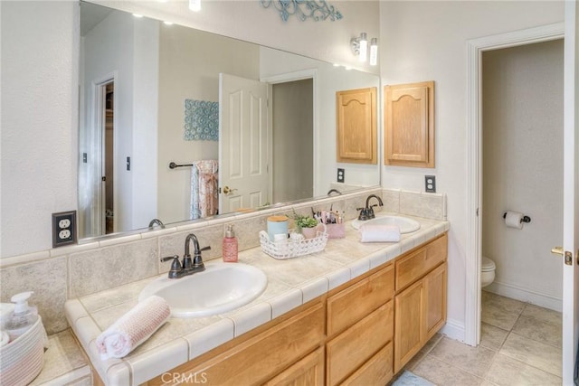 bathroom with tile patterned flooring, vanity, and toilet