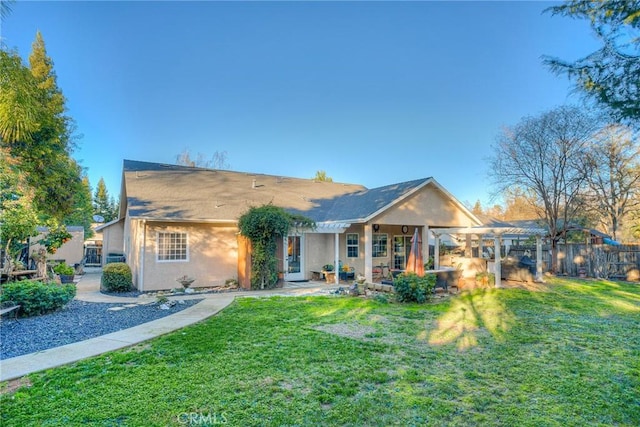 rear view of house featuring a lawn and a pergola