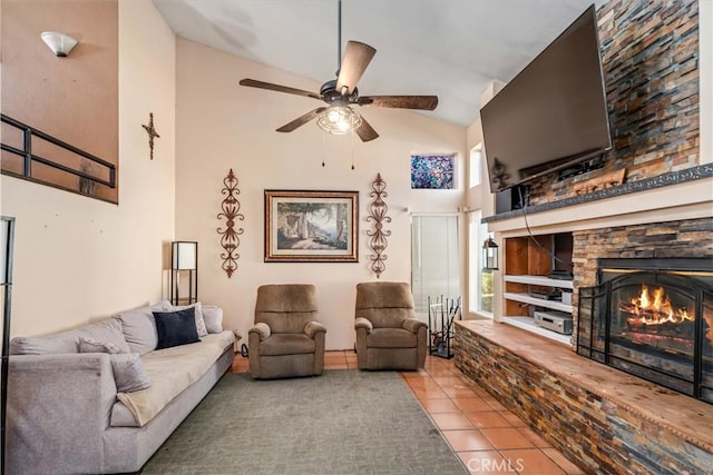 tiled living room featuring ceiling fan, a stone fireplace, and lofted ceiling