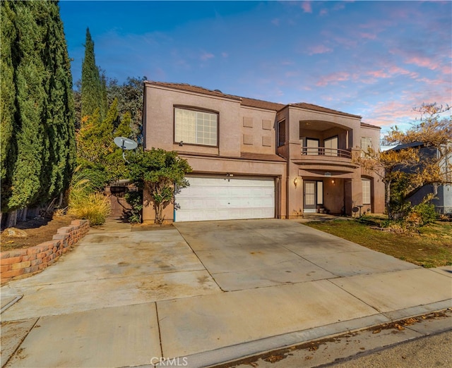 view of front of property featuring a garage and a balcony