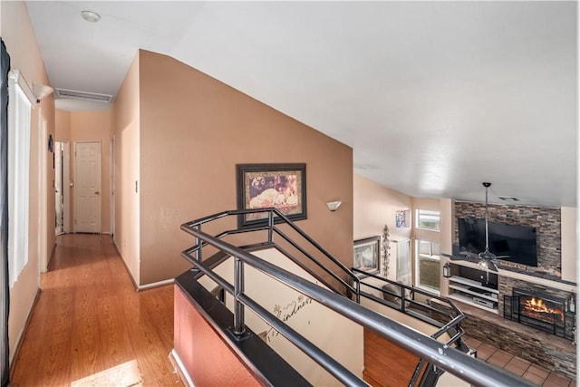 hallway with light hardwood / wood-style floors and lofted ceiling