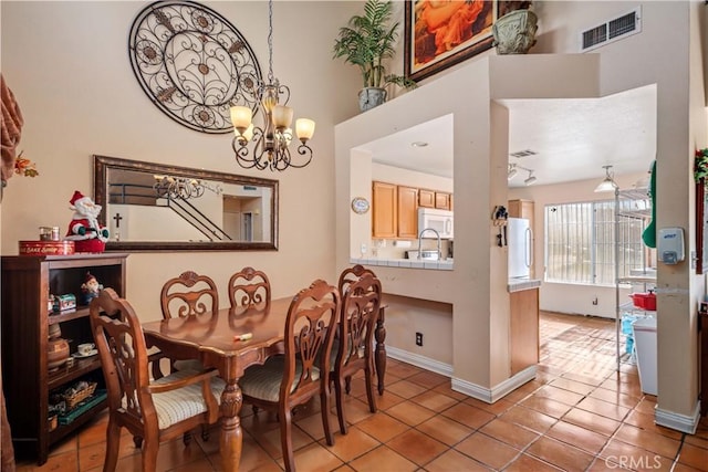 dining space featuring light tile patterned flooring and a chandelier