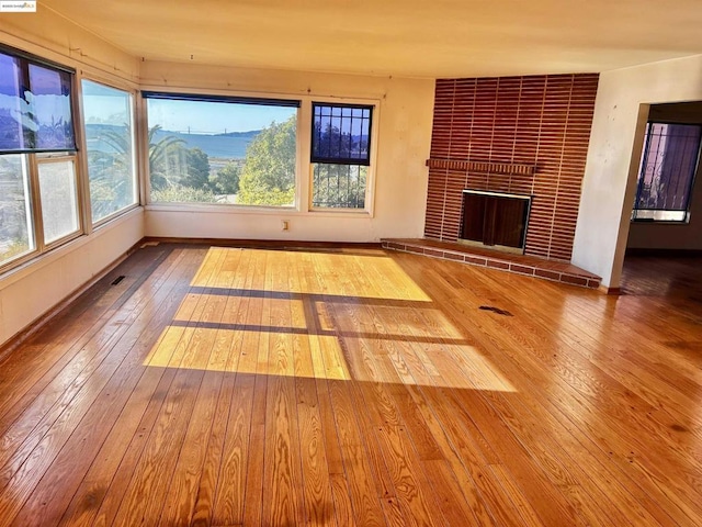 unfurnished living room featuring a fireplace and wood-type flooring