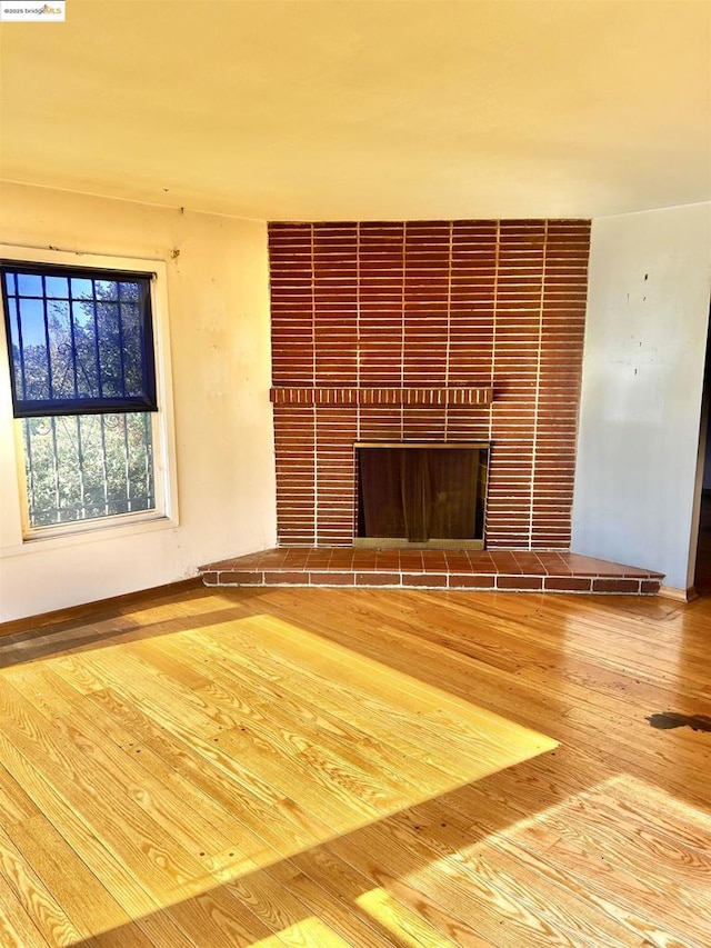 unfurnished living room with hardwood / wood-style flooring and a fireplace