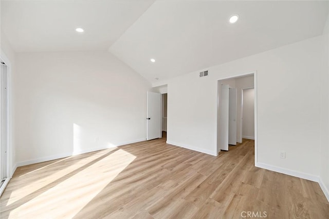 unfurnished bedroom featuring lofted ceiling and light hardwood / wood-style flooring