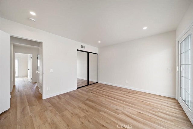 unfurnished bedroom with light hardwood / wood-style floors and a closet