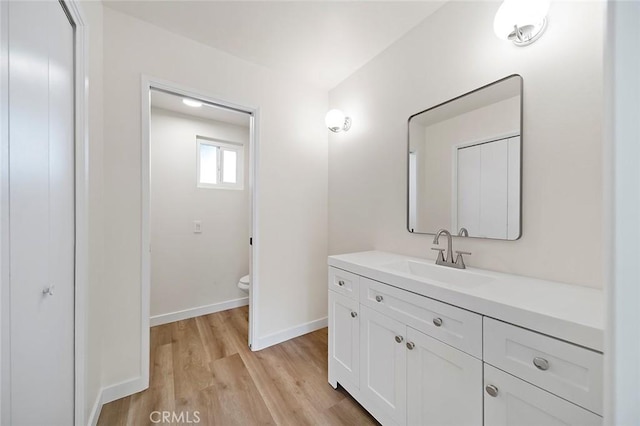 bathroom with hardwood / wood-style floors, vanity, and toilet