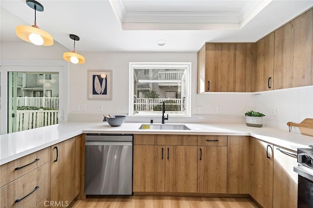 kitchen with ornamental molding, a tray ceiling, sink, pendant lighting, and dishwasher