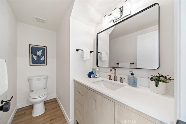 bathroom with wood-type flooring, vanity, and toilet