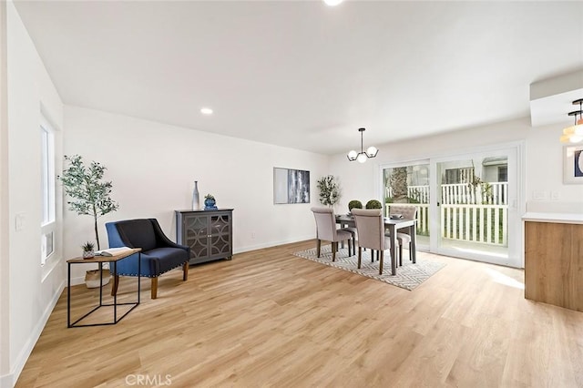 dining room with a notable chandelier, light hardwood / wood-style floors, and a wealth of natural light