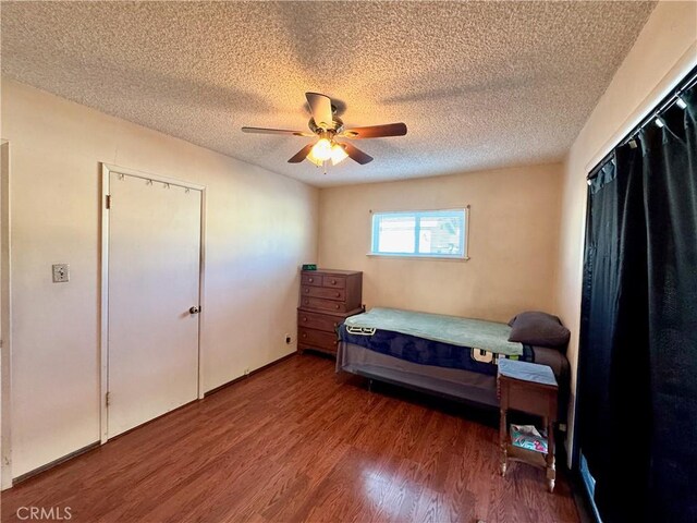 bedroom with a textured ceiling, ceiling fan, and hardwood / wood-style flooring