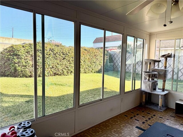 unfurnished sunroom featuring ceiling fan