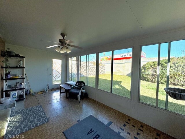 unfurnished sunroom with ceiling fan